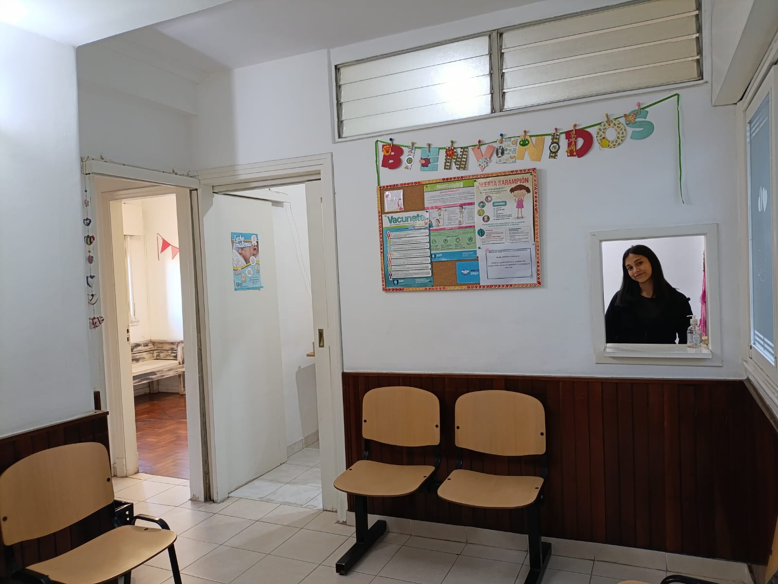 Sala de espera del consultorio, con cartel de bienvenida y sillas